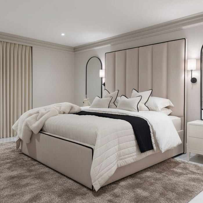 Custom Belle bed frame with super high upholstered panel headboard in beige, with white bedding and nightstands